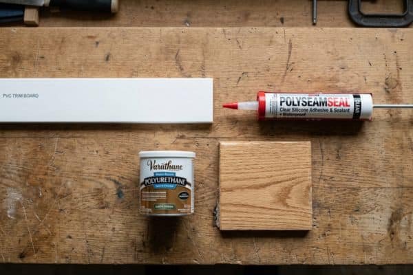 Humidity-safe materials for a DIY bathroom mirror frame including PVC trim, silicone, and polyurethane